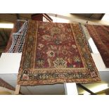 A needlepoint rug, the twin floral decorated bands with rouge borders,