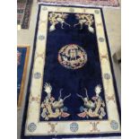 A Chinese style carpet with blue field and cream border together with smaller similar