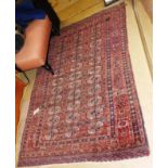 An antique Turkoman rug, the all over design on teracotta ground within a repeating border.
