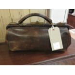 A vintage leather Gladstone bag.