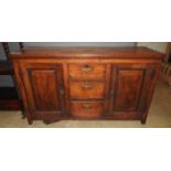 An oak 19th Century dresser base with three central drawers flanked by cupboards