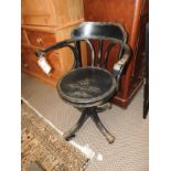 A wrought iron swivel tub chair with solid seat raised on casters