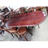 An oval mahogany dining table with six Andy Thornton bentwood chairs