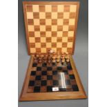 A contemporary chessboard with faux marble insert and weighted pieces along with a similar complete