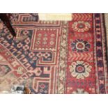 An antique Malayer rug, the all over geometric design on ruby ground within an ivory border.