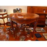 A French style inlaid walnut low table the circular top raised on cabriole supports with gilt metal