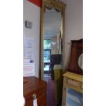 An early 20th century wall mirror of tall narrow proportions the rectangular plate within giltwood