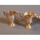 Two hallmarked silver twin handled miniature trophies.