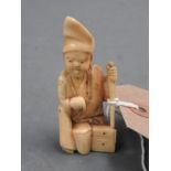 A signed ivory netsuke figure of a gentleman with staff