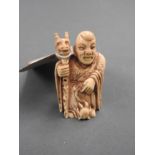 An Oriental okimono ivory seated figure,