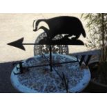 A black metal weather vane having badger