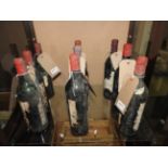 A collection of nine vintage bottles of red wine, of various conditions,