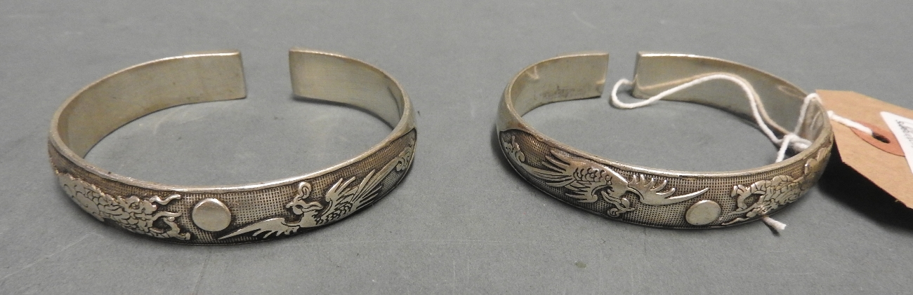 A pair of white metal Chinese style bangles