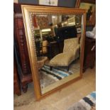 A gilt rectangular wall hanging mirror with bevelled plate