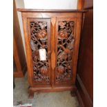 A teak carved Chinese style cabinet with twin panel doors and bird detail