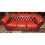 A red leather button back three seater Chesterfield sofa