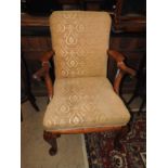 A Georgian style walnut armchair upholstered in gold patterned fabric and raised on cabriole pad