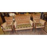 An Edwardian sofa suite with two armchairs upholstered in beige velour on castors