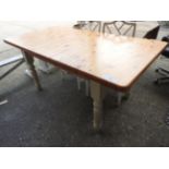 A farmhouse pine kitchen table with white painted legs
