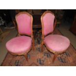 A pair of French walnut boudoir chairs upholstered in chequered pink fabric with cabriole supports
