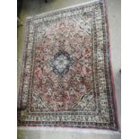 A Persian style rug with central blue medallion on pink ground