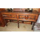 A 19th century oak dresser base on baluster legs with twin drawers