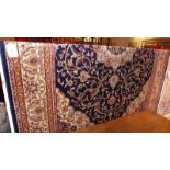 A Kashan style carpet with a floral medallion on a navy blue field,