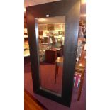 A contemporary dark wood mirror with rec