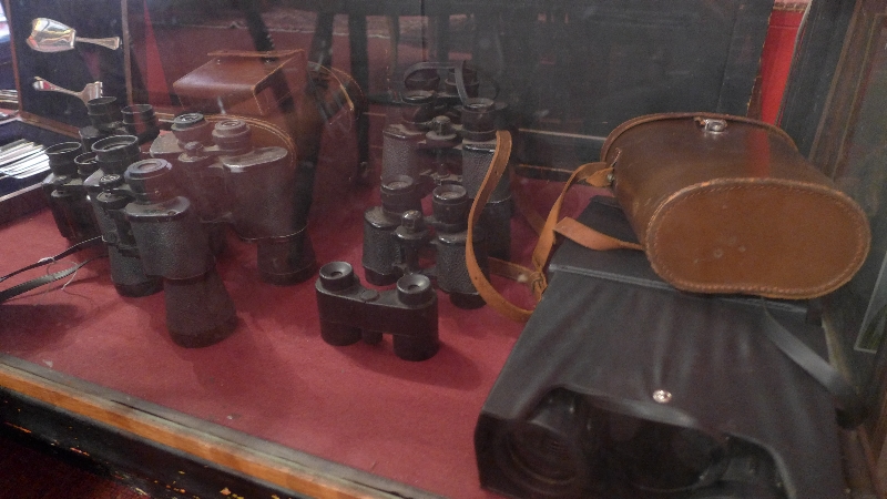 A large collection of various binoculars,