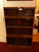 A mid 20th century oak Mintys stacking bookcase of four sections with sliding glass doors