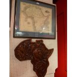 A framed map of Africa together with a wood carving in the form of the African continent depicting