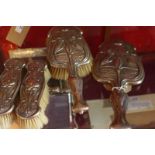 A set of four hallmarked silver Art Nouveau dressing table brushes having images of kingfishers in