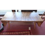 A retro 1960's Ercol light elm coffee table having two drop flap extensions and slatted undertier