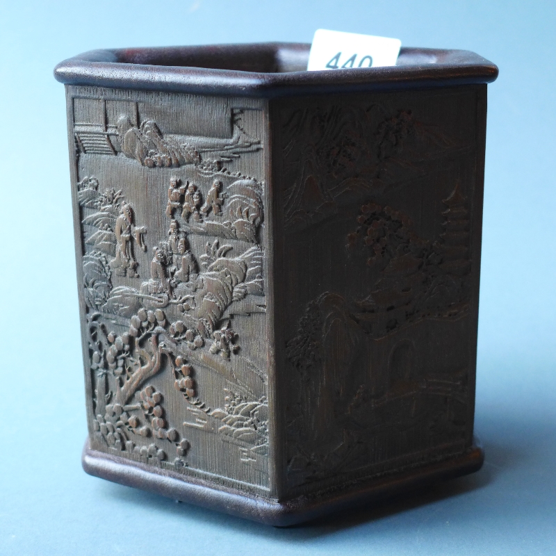 A Chinese carved hardwood brush pot having landscape images in relief