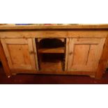 A 19th century pine butchers block having open recess and pair of panelled doors