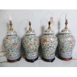 A set of four Oriental porcelain table lamps of lidded urn form on wooden bases (4)
