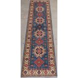 A fine kazak runner, the repeated geometric design on a sky blue ground within golden border with