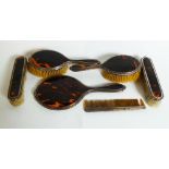 A six piece tortoiseshell and silver dressing table set comprising mirror, brushes, comb
