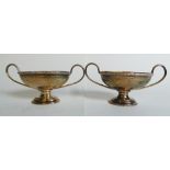 A pair of silver neoclassical twin handled urns, indistinctly marked