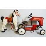 A vintage toy pedal tractor in a distressed red painted finish, along with a 1950s Mobo tin metal