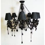 A contemporary German designer black glass nine branch chandelier, having cut glass droplets and