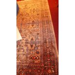 A Persian design rug the beige ground having repeating floral motifs in a triple border