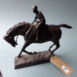 A bronze of a jockey on horseback signed