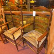 A pair of early 20th century oak armchair having rush seats and raised on stretchered supports