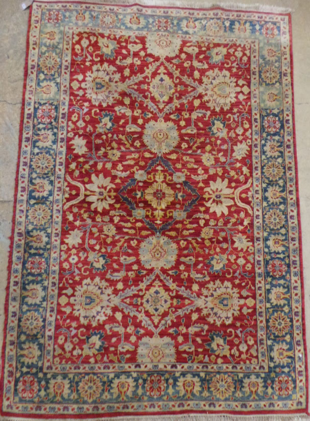An Indian Agra carpet, the all over vine and palmette design on an abrashed terracotta ground within