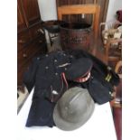 A collection of militray uniforms and a toleware box containing various hats