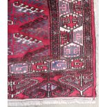 A fine North East Persian yamut carpet, 307cm x 210cm, repeating geometrical motifs on a rouge field