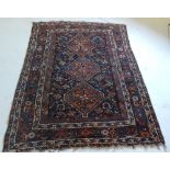 An antique Persian Qashgai rug, the triple pole ruby medallion on a midnight blue ground with