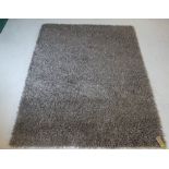 A contemporary designer hand woven carpet, having an all over abrashed silver grey thick piled