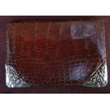 A crocodile skin wallet with silver corners, dated 1901